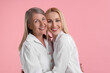 © New Africa - Family portrait of young woman and her mother on pink background