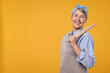 © New Africa - Happy housewife with rolling pin on orange background, space for text
