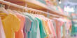© MNStudio - Neat stacks of folded kids clothes on the shop shelves. Pastel colored children shirts, blouses and sweaters in a neatly organized clothing store.