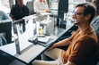 © Jacob Lund - Happy business man smiling as he listens to a presentation in a business meeting