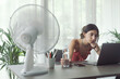 © StockPhotoPro - Woman cooling herself at home