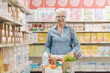 © StockPhotoPro - Confident senior woman doing grocery shopping at the supermarket