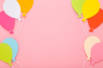 Wall Mural - Colorful balloon shapes from application paper with white strings on light pink table background. Pastel color. Closeup. Empty place for inspirational text, quote or sayings. Top down view.