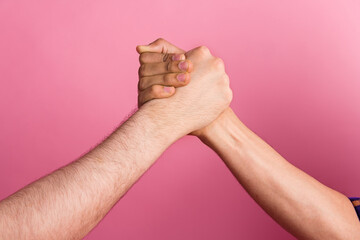 Photo of two people hold hands fist unity team greeting together strong concept isolated pastel color background