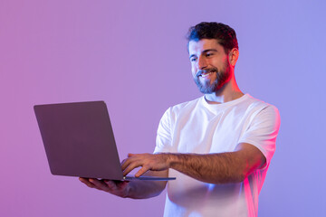 Aufkleber - a man in a white shirt is standing and holding a laptop in his hands. he appears focused on the scre