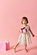 © LIGHTFIELD STUDIOS - Little girl in white dress holding pink gift box.