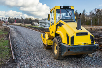 Wall Mural - yellow road roller, newly built railway line, gravel embankment, construction works, reconstruction of the railway line