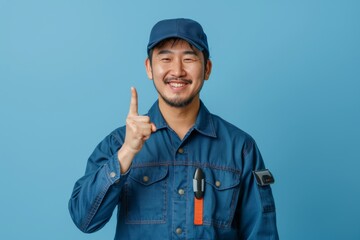 Wall Mural - A man in a blue shirt is smiling and pointing his finger