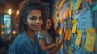 © AS Photo Family - A focused young woman interacts with a wall covered in colorful sticky notes, indicating a creative or planning process