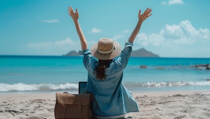 A woman sits on the beach with her arms raised in celebration, working remotely with her laptop. Perfect for themes of freedom, remote work, and summer vacations.