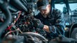 © horizon - The mechanic is working on the engine of an electric truck, which has wires and other parts attached to it. He wears dark blue work  with blue gloves and hat.