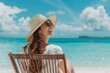 © justjupiter - Woman relaxing on a beach chair by the sea under a sunny sky, wearing a hat and sunglasses, with a rainbow in the background.