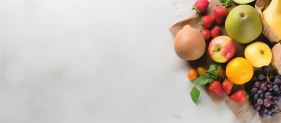 Poster - There is a copy space image featuring a flat lay of a shopping paper bag filled with nutritious fruits on a grey background