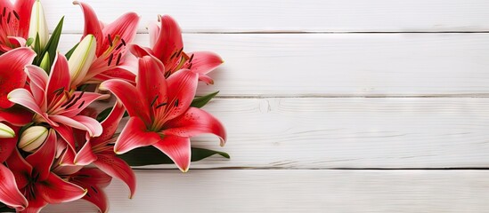 Poster - A bouquet of lily flowers adorned with a red ribbon displayed on a white wooden background providing ample copy space for text or images