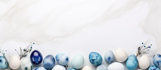 Poster - Easter greeting card mockup with stylish eggs forming a frame placed on a white wooden background Modern eggs painted in blue and grey marble using natural dye creating a stunning copy space image