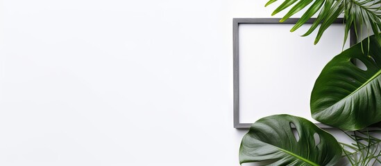 Poster - A gray background with a monstera leaf and an empty photo frame mockup Flat lay top view with copy space for text or images