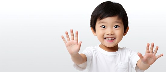 Poster - A happy and attractive Asian child showcasing an area for text or images on their open palm against a plain white backdrop. with copy space image. Place for adding text or design