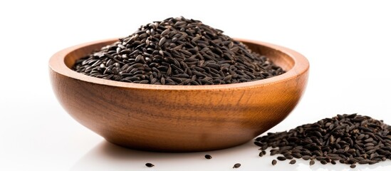 Poster - Copy space image of black cumin seeds presented in a wooden bowl isolated on a white background The pile showcases nigella sativa seeds captured from various angles creating a diverse and visually ap