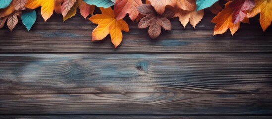 Poster - An autumnal copy space image with a wooden background embraced by vibrant leaves
