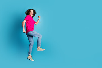 Poster - Full length portrait of nice young man jump rush empty space wear t-shirt isolated on blue color background