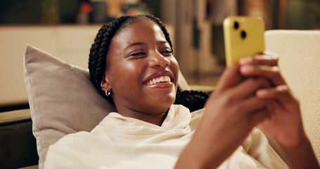 Fototapete - Happy, typing and black woman with phone on sofa for online chat, communication and networking. Relax, home and person on smartphone for social media, funny website and internet news in living room