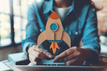 Poster - Startup business concept. A person holding an icon of rocket or space ship with arrows up, representing growth and success in business.