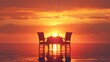 A table with two chairs and a wine glass is set up on the beach at sunset