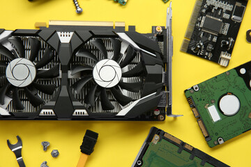 Poster - Graphics card and other computer hardware on yellow background, flat lay