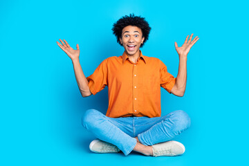 Poster - Full length photo of impressed positive guy dressed orange shirt rising hands arms empty space isolated blue color background