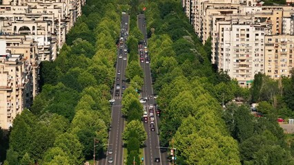 Wall Mural - Bucharest aerial 4k video. Beautiful view of the landmarks of Bucharest from Unirii area (boulevard, fountains and Palace of the Parliament) during a summer day with vivid green tree color.