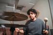 © ADDICTIVE STOCK - Young male drummer playing in a home studio setup