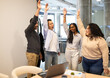 © ADDICTIVE STOCK - Celebratory high-five among coworkers in office