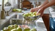© Irina Ukrainets - Person washing fresh green apples in a kitchen sink. Bright natural light. Home preparation for eating or cooking. Lifestyle and healthy living concept. AI