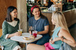 © Ilona - Three women drink cooling lemonades and have lunch while sitting in a cafe on a summer day.