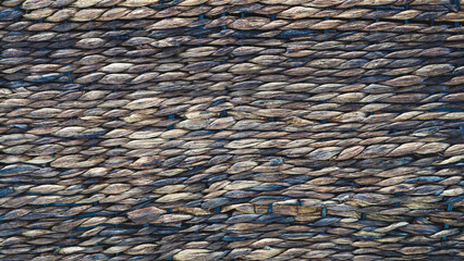 Poster - A close up of a wall made of brown and tan stones. The wall is made up of many small stones, and the stones are arranged in a way that creates a textured and rough appearance