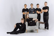 © Vasil - A group of young men and women are posing for a photo in front of a chair. Scene is casual and friendly, as the group is comfortable with each other and he is enjoying their time together