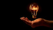 © Michael - A hand appears to hold a glowing light bulb with the word 'idea' inside, on a dark background
