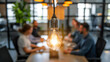 © Michael - Focused light bulb in a modern office with blurred team meeting in the background