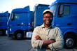 © littlewolf1989 - Portrait of smiling driver standing in front of his trucks at parking lot.