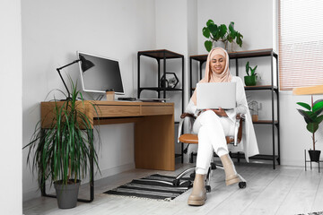 Poster - Muslim businesswoman working with laptop in office