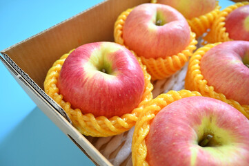 Wall Mural - beautiful pink apple in the box on blue background