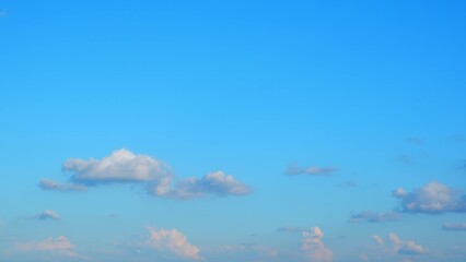 Wall Mural - A clear blue sky with a few scattered clouds. The clouds are primarily situated in the lower part of the image, adding a touch of softness to the vast expanse of blue above. Blue sky background.
