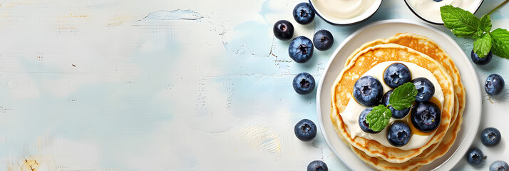 Top view of a copy space image featuring light background with cottage cheese pancakes sour cream and blueberries Suitable for breakfast or lunch