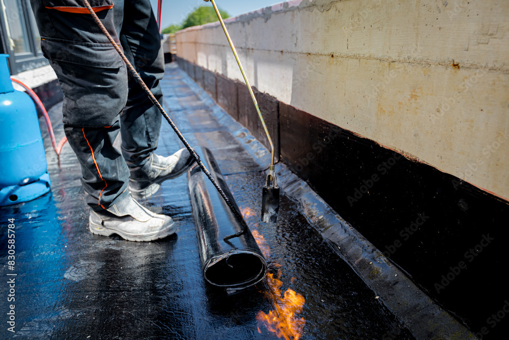 Worker using a gas burner, propane blowtorch to melt and arrange resin ...