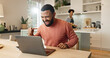 © peopleimages.com - Businessman, celebration and laptop on table for online research, reading result and communication in home. Success, male person and technology in house for internet connection and investing