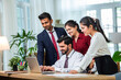 © StockImageFactory - Indian young businesspeople using laptop in group meeting at desk