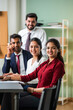 © StockImageFactory - Indian young businesspeople using laptop in group meeting at desk