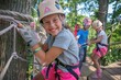 © Afeefa_Rehman - Little girl having fun at adventure park. Kid climbing trees in park. Cute little girl in climbing safety equipment in a tree house or in a rope park climbs the rope.