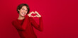 © My Ocean studio - Photo of a gorgeous smiling tender stylish woman who shows heart gesture with help of her hands isolated on a red bright wall.