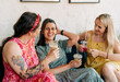 © Ilona - Young happy cheerful women celebrating summer festival. Friends sitting on the sofa talking and laughing and drinking lemonades.
